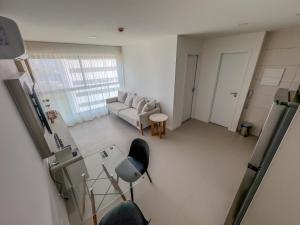 einen Blick über ein Wohnzimmer mit Sofa und Stühlen in der Unterkunft Apartamento em Recife, condomínio de luxo in Recife