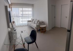 ein Wohnzimmer mit einer Couch und einem Glastisch in der Unterkunft Apartamento em Recife, condomínio de luxo in Recife + 6 Fotos