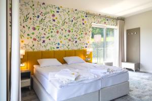 a bedroom with a large bed with a floral wallpaper at Miodowa Klinika in Kamianna +43 photos