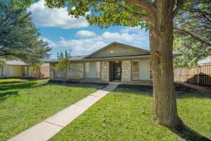 a house with a tree in front of it at Stunning 4BR 2BA Hot Tub Cozy Holiday Home in Plano in Plano