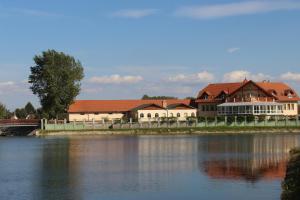 a large building next to a large body of water at La Curia Panzió in Dunaszeg