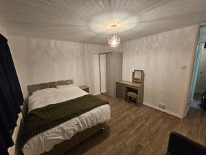 a bedroom with a bed and a desk and a television at Your Cozy Home Away From Home in Surbiton