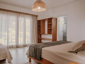 a bedroom with a bed and a large window at Casa Caetano - Peninsula de Maraú - Taipus de Fora in Taipu