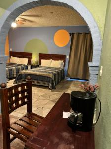 a bedroom with two beds and a table with a coffee maker at Hotel Camino de Allende in San Miguel de Allende