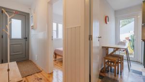 Un pasillo con una puerta, una mesa y un escritorio. en Pátio Vilareto - Villa Clara, en São Domingos de Rana