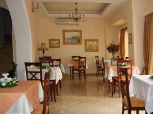 a restaurant with tables and chairs with white tablecloths at Nefeli Boutique Hotel in Agios Kirykos