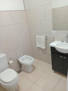 a white bathroom with a toilet and a sink at Dpto Posadas in Junín