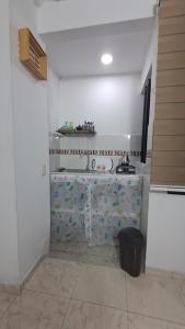 a white kitchen with a counter with a trash can at Apartaestudio Con Entrada Independiente in Ibagué