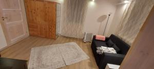 a living room with a black couch and a door at Marja Apartment in Tartu