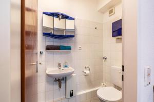 a bathroom with a sink and a toilet at Urbanes Nest, ideal für Entdecker in Dinslaken