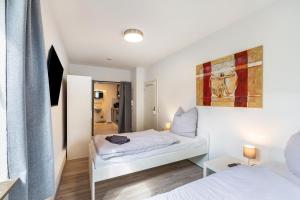 a small bedroom with two beds and a mirror at Urbanes Nest, ideal für Entdecker in Dinslaken