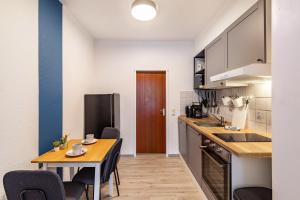 a kitchen with a table and a dining room at Urbanes Nest, ideal für Entdecker in Dinslaken +12 photos