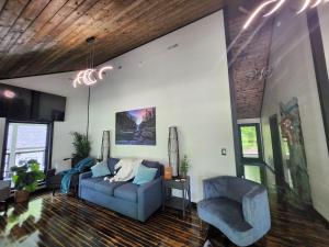 a living room with a blue couch and a chair at Life's Good Retreat Main House in Brevard