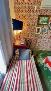 a bed in a room with a desk and a computer at Hospedaria Santa Bárbara in Rio de Janeiro