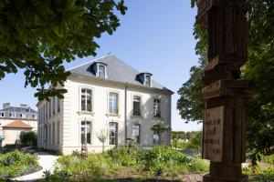 a large white house with a sign in front of it at Clos Vauban - Relais & Chateaux in Langres