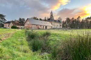 an old building in a field with a field of grass at Les Longères de Montfranc - Gîte in Pierrefitte-sur-Sauldre