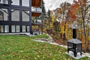 una casa con chimenea frente a un patio en Chalet 35, en Stoneham