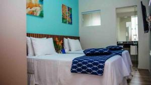 a bedroom with two beds with blue walls at Asenza Hotel in Pitimbu +96 photos
