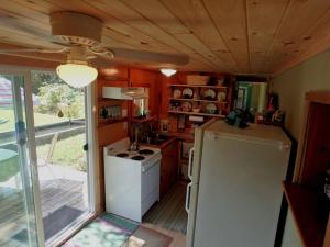 a kitchen with a white refrigerator and a stove at Nantahala Spiritual Retreat - Remote and Peaceful! in Topton
