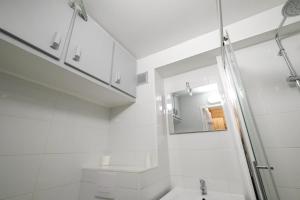 レ・メニュアールにあるWooden paradise / 6 personsのシャワーと洗面台を備えた白いバスルーム