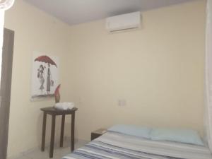 a bedroom with a bed and a table with an umbrella at Casa de Nylva Beach Pipa in Pipa