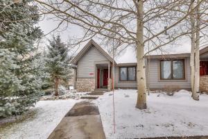 a house with a red door in the snow at Copper Mtn Resort Duplex with Golf Course Views! in Frisco