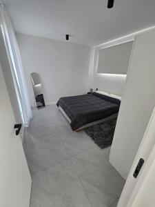 Un dormitorio con una cama negra en una habitación blanca en Private Accommodation Nino No 1, en Albion 14 fotos más