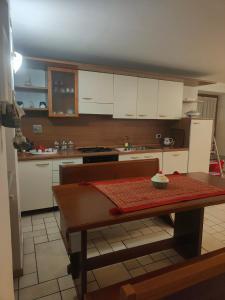 a kitchen with white cabinets and a table in it at Da ME in Aosta