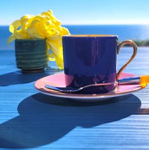 a blue coffee cup on a pink plate on a table at Kaze no iro Bijutsukan - Vacation STAY 67833v in Asahi