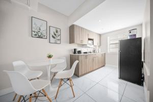 cocina con mesa y sillas blancas en una habitación en The Samantha by Lowkl, en Miami Beach