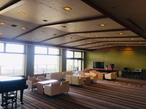 a waiting room with tables and chairs and a piano at Hotel Kaishunro - Vacation STAY 54369v in Hamamatsu