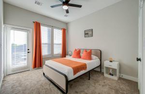 a bedroom with a bed with orange pillows at The Orange HTX by NRG Med Cent in Houston