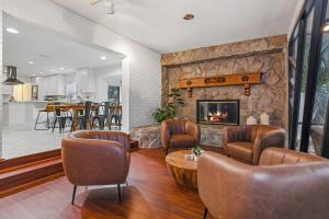 a living room with leather chairs and a fireplace at Golden Retreat: Expansive 6BR Home w Heated POOL ~ in Seminole