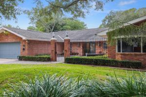 a brick house with a garage at Golden Retreat: Expansive 6BR Home w Heated POOL ~ in Seminole