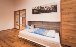 a bedroom with a bed with a wooden headboard at Ferienwohnung Alexander Kleinheinz in Rettenberg