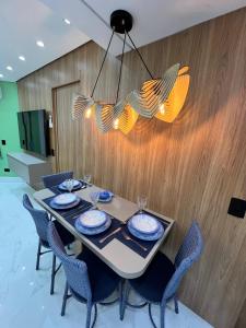 a dining room table with chairs and a chandelier at BARRAVENTO RESIDENCE - RIVIERA SÃO LOURENçO in Bertioga +80 photos