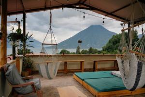 a porch with hammocks and a view of a mountain at Casa Madera in San Marcos La Laguna