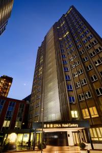 a tall building with a unitedhealth company sign in front of it at UNA Hotels Century Milano in Milan
