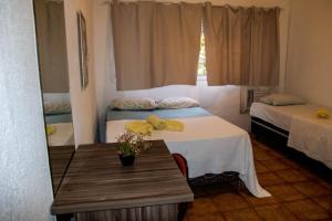 累西腓Casa do Meio Pousada的一间设有两张床的房间和一张鲜花桌子