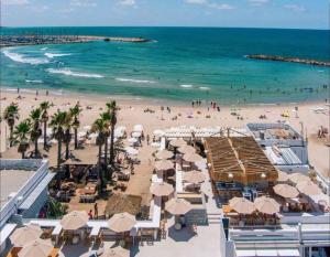 una playa con sombrillas y gente en la playa en Luxury Studio Beach Flat 527, en Tel Aviv