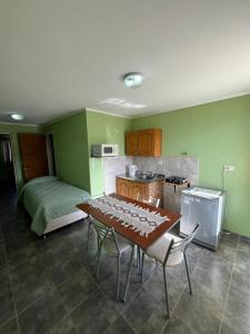 a kitchen with a table with chairs and a bed at Departamentos El Alamo in Comandante Luis Piedra Buena