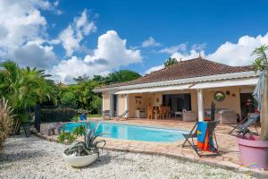 a villa with a swimming pool and a house at Villa Bleue, piscine, vue mer in Le Diamant