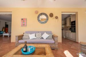 a living room with a couch and a table at Villa Bleue, piscine, vue mer in Le Diamant