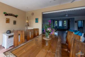 a living room with a wooden table and a dining room at Villa Bleue, piscine, vue mer in Le Diamant