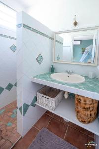 a bathroom with a sink and a mirror at Villa Bleue, piscine, vue mer in Le Diamant