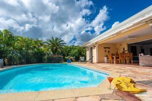 a swimming pool in the backyard of a house at Villa Bleue, piscine, vue mer in Le Diamant