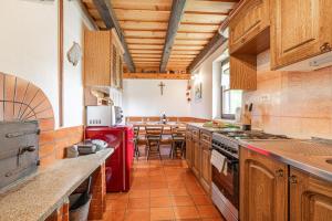 a kitchen with wooden cabinets and a red refrigerator at Holiday House Podhamer Boris with private Wellness in Ljutomer +39 photos