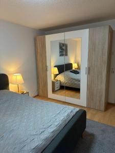 a bedroom with a bed and a large mirror at Schöne Ferienwohnung Bodenseeregion in Singen