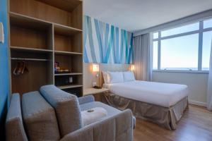 una habitación de hotel con una cama y un sofá en Mercure Rio de Janeiro Barra da Tijuca, en Río de Janeiro