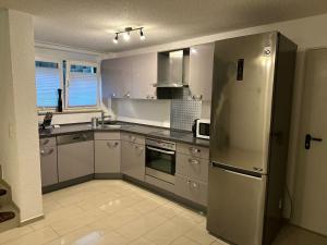 a kitchen with a stainless steel refrigerator and appliances at Schöne Ferienwohnung Bodenseeregion in Singen